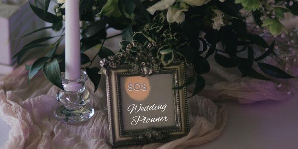 Tavolo da matrimonio con portafoto e scritta SOS Wedding Planner